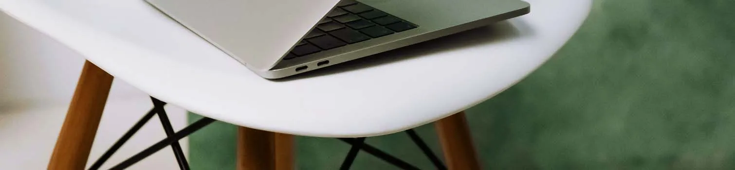 Laptop auf einem weißen Tisch auf Gras.