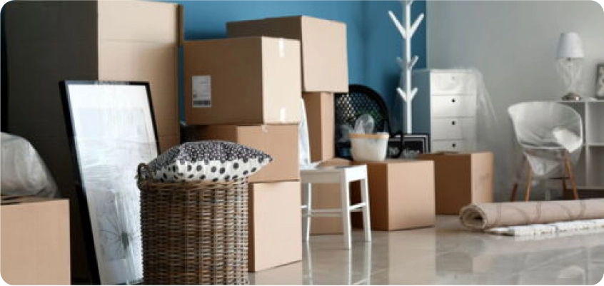 Mehrere Umzugskartons und Möbel stehen in einem Raum während eines Umzugs.